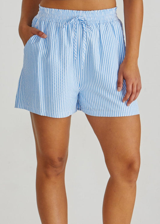 Close up of Lady wearing the SASS Alani Short in blue white stripe seersucker with elastic waist, drawcord and side pockets. Available at Loloma Living Tamborine Mountain - stockist of SASS and Betty Basics.
